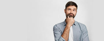 Guy standing and thinking on grey background