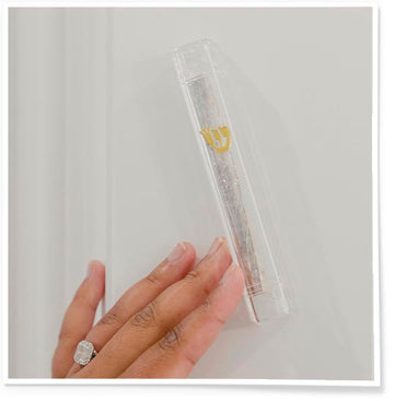 Modern transparent Mezuzah Case on the door and woman hand touching it